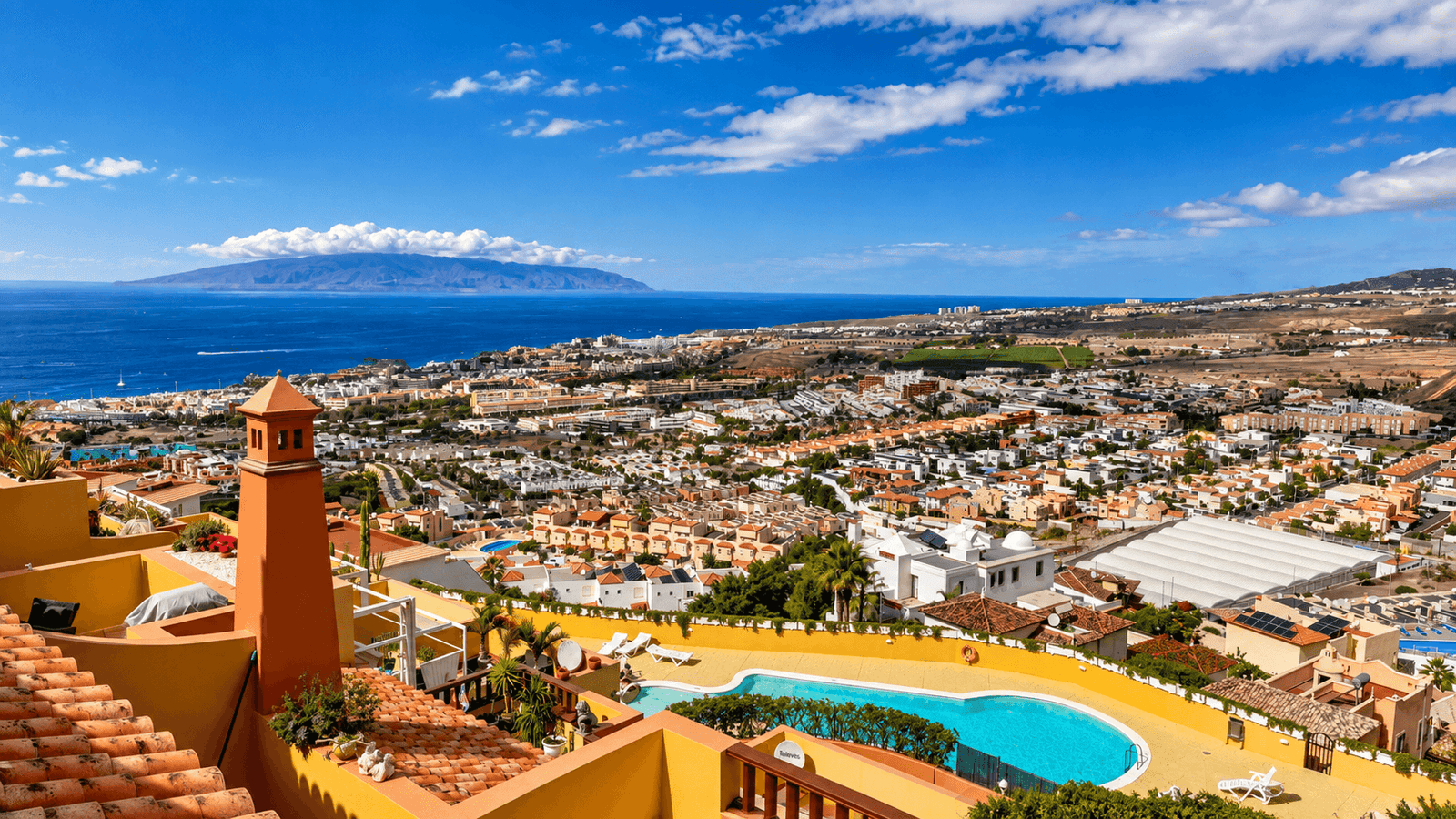 Panoramic view over Costa Adeje, Tenerife, with coastal areas, hillside homes and La Gomera in the distance