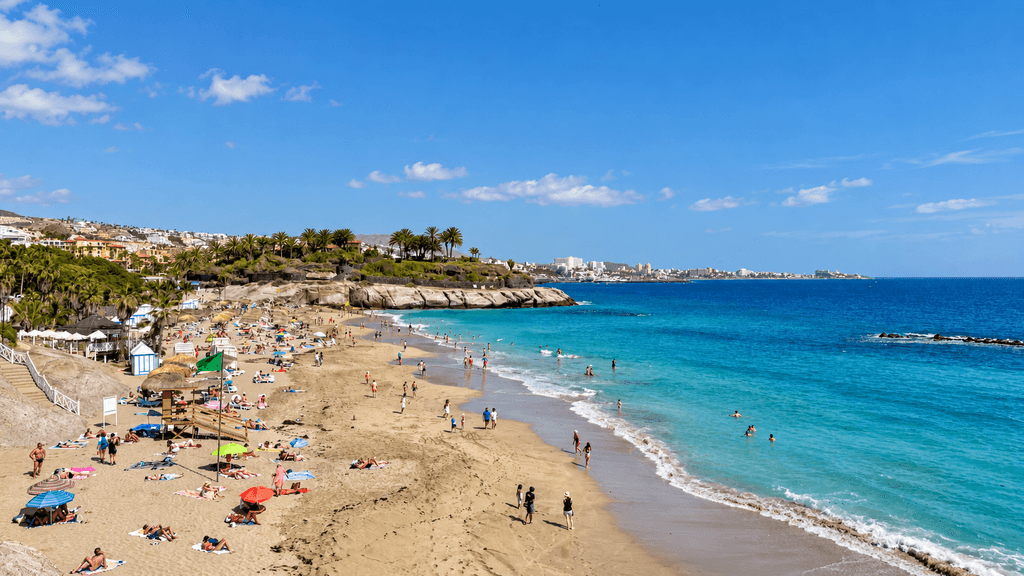 Playa del Duque beach in Costa Adeje, Tenerife, with the coastline and resort area in the distance