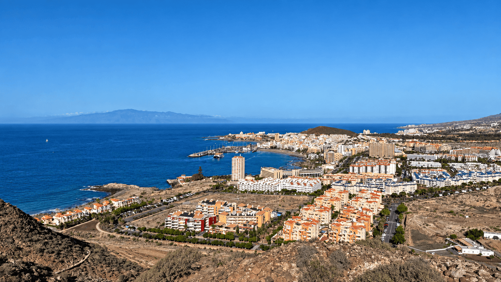 Elevated view over Los Cristianos in Tenerife showing the coastline, harbour and town