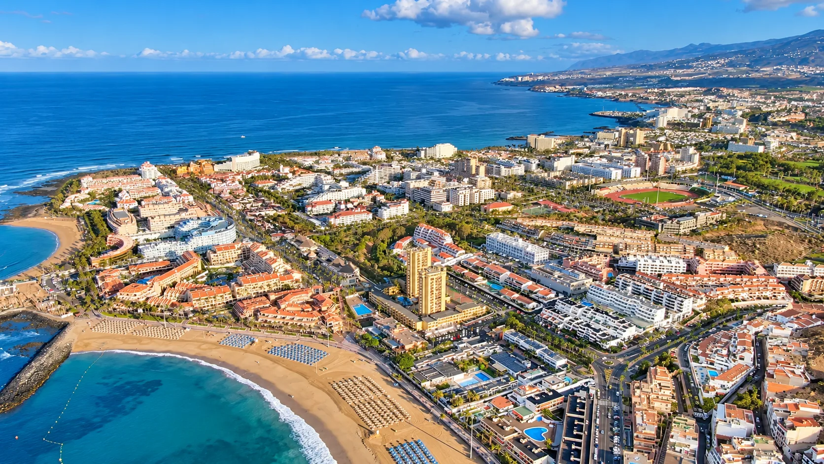 Aerial view of Playa de Las Américas in Tenerife showing the coastline, beaches, hotels and residential areas